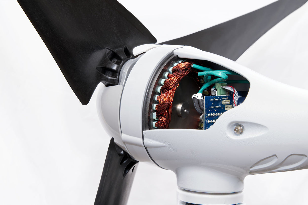 Close-up of a white wind turbine blade hub with the inner motor assembly exposed, showing copper windings, green wiring, and electronic components, with part of a black blade visible.